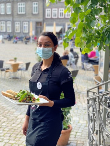 Auszubildende Person im Projekt I love Gastro mit Teller in der Hand.