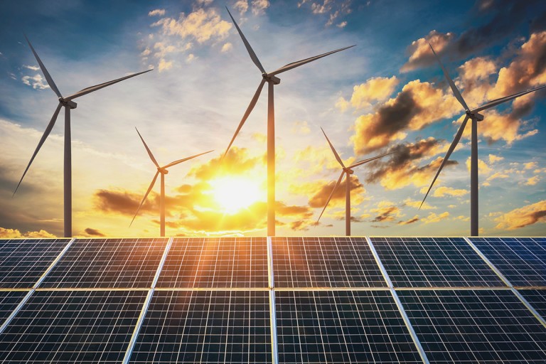Das Bild zeigt eine Landschaft mit Windrädern und Solaranlagen. Die Windräder drehen sich im Wind, während die Solaranlagen Sonnenlicht einfangen. Dieses Bild symbolisiert den Einsatz erneuerbarer Energien zur nachhaltigen Stromerzeugung und den Übergang zu einer klimafreundlichen Energieversorgung.